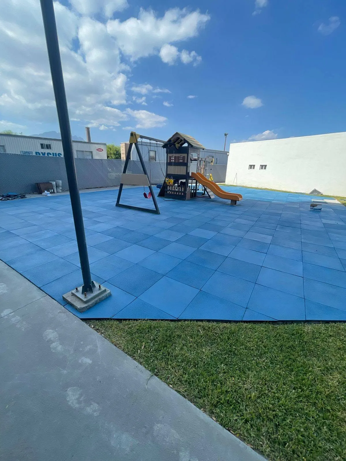 Playground equipment on blue rubber flooring outdoors