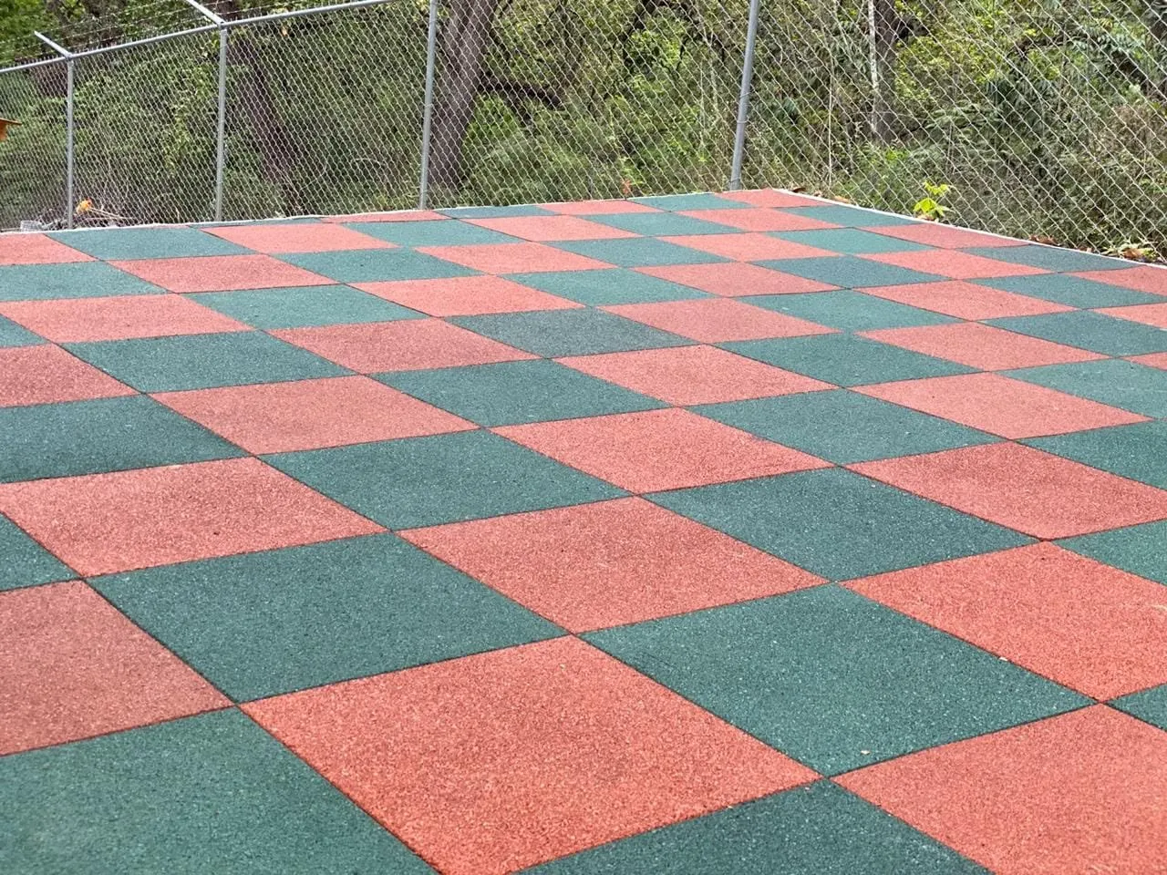Outdoor patio with rubber tile in a red and green checkerboard