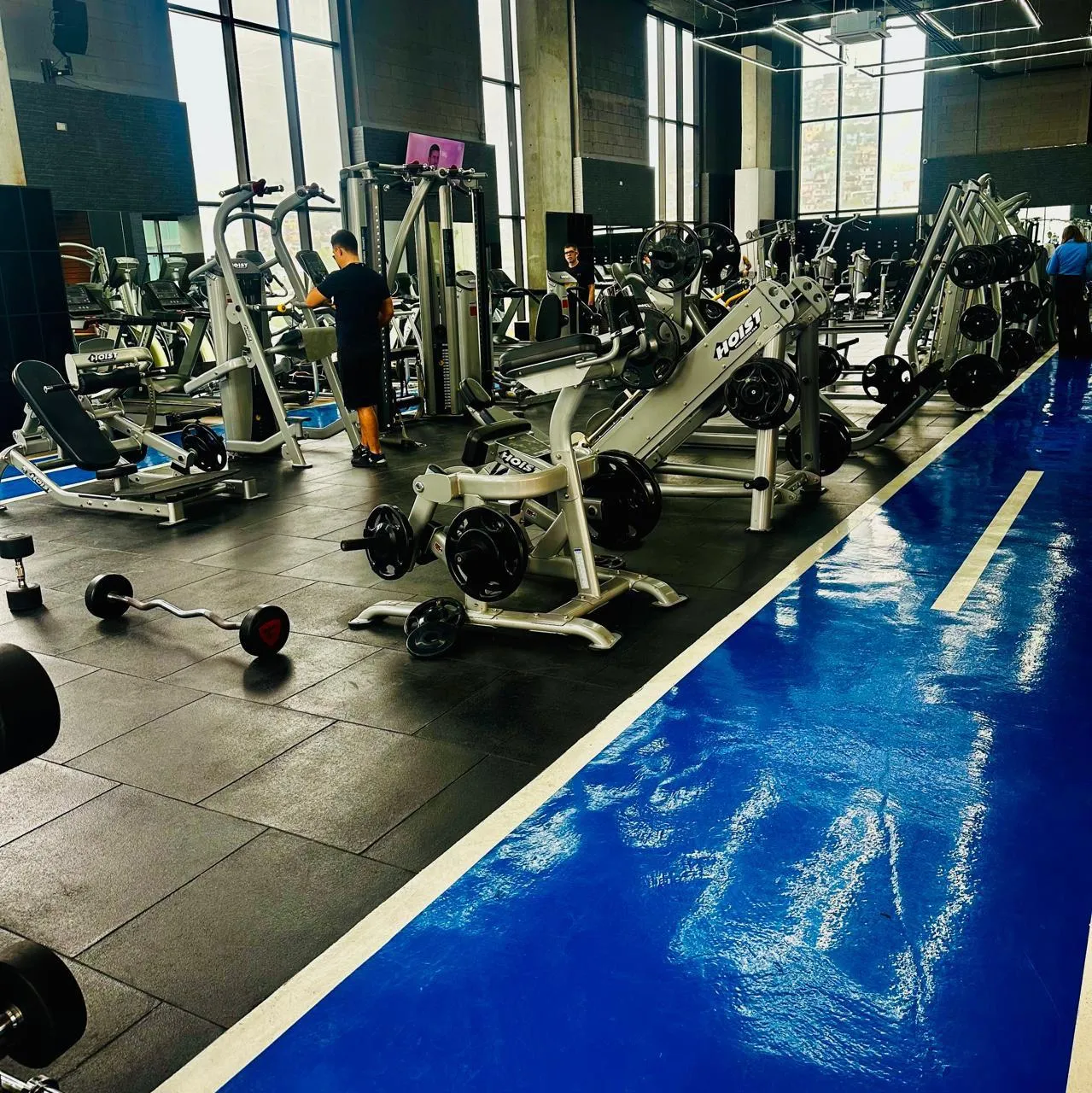Gym with black rubber tile and a glossy blue running track
