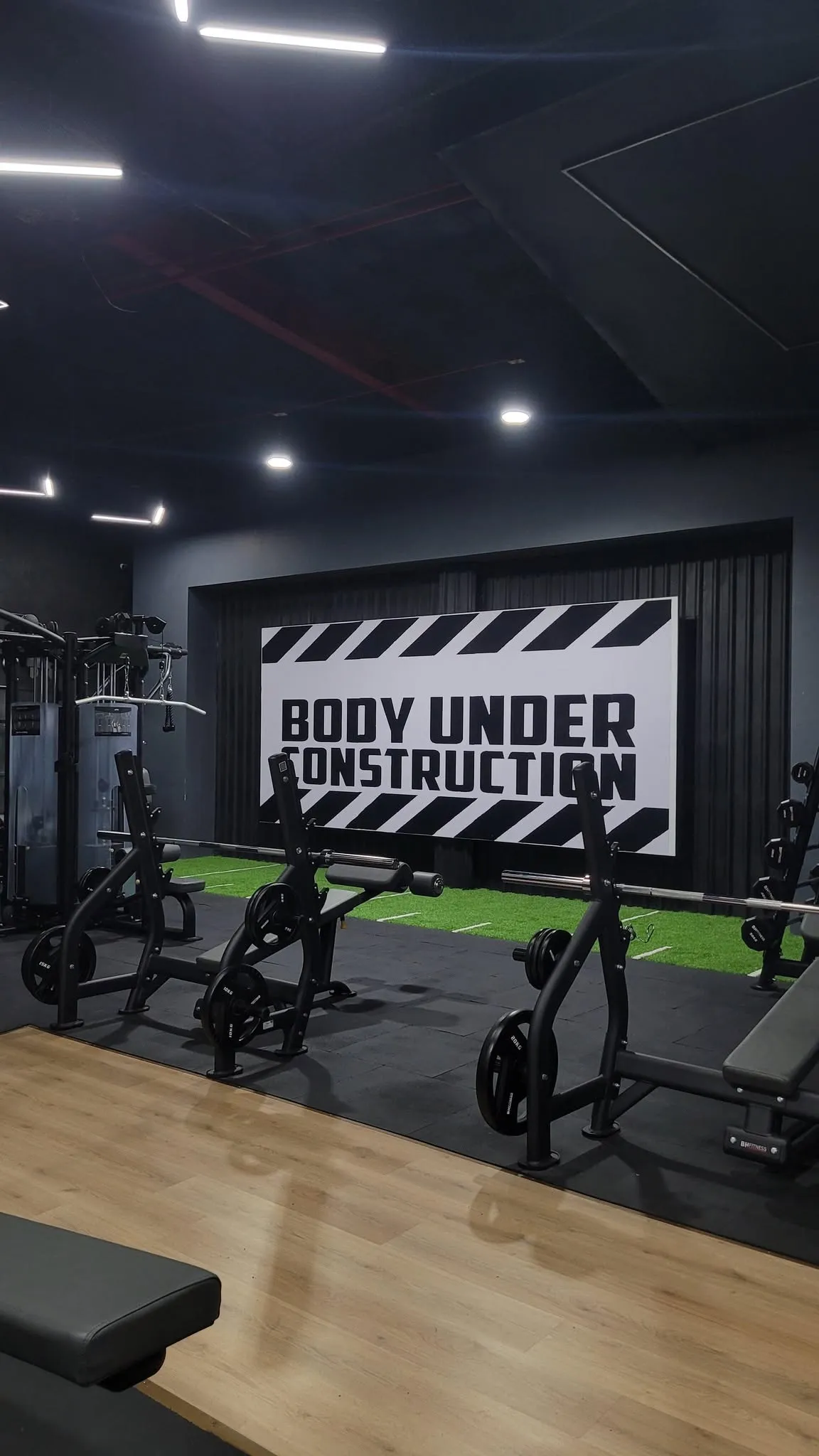 Free weight area of a gym on black rubber tile
