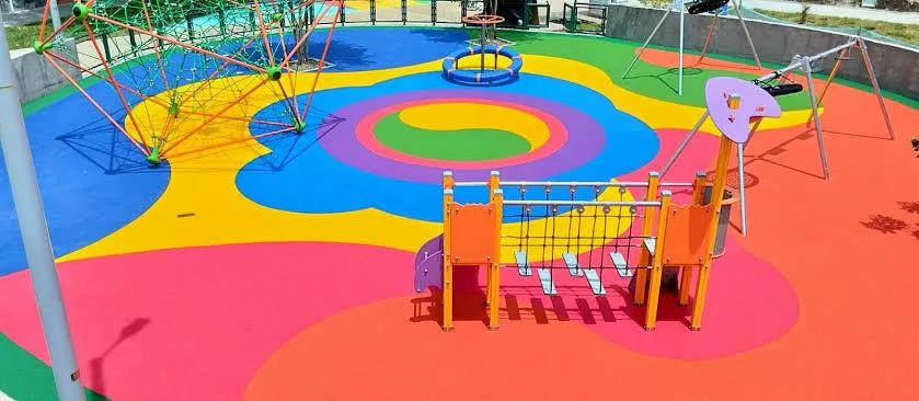Playground equipment on seamless multicolor poured rubber flooring