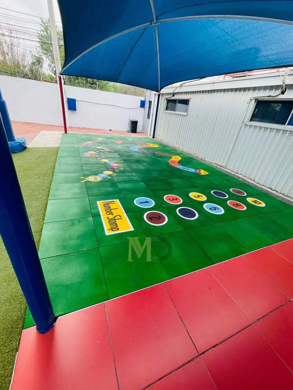 Patio with number games painted on green and red rubber tile